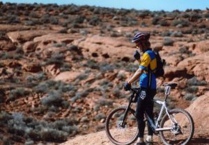 a mountain biker looking out over the red desert of southern Utah a mountain biker looking out over the red desert of southern Utah